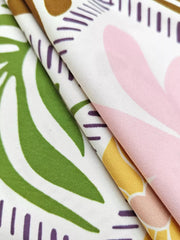 Vibrant print maternity cami dress with green leaves, pink and yellow abstract shapes.