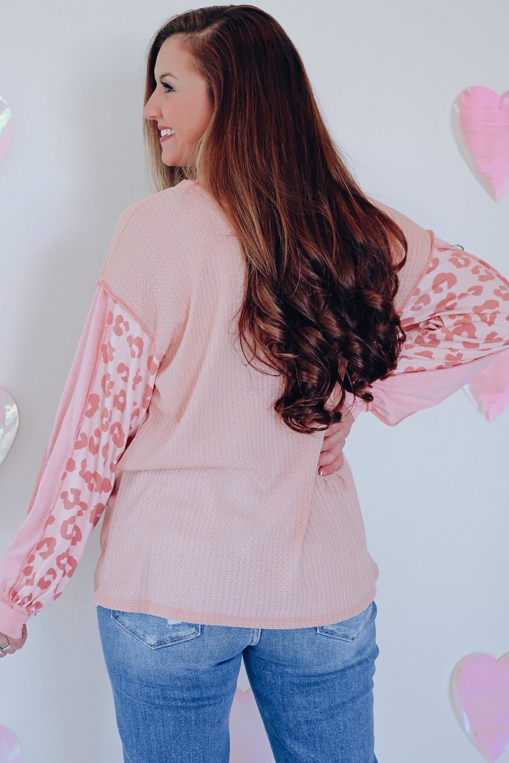 Blush pink waffle knit top with leopard print sleeves and crew neck.