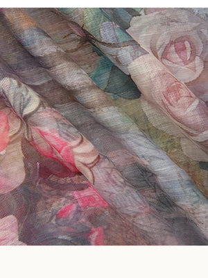 Pastel floral print sheer fabric dress detail with soft pink roses and green leaves.