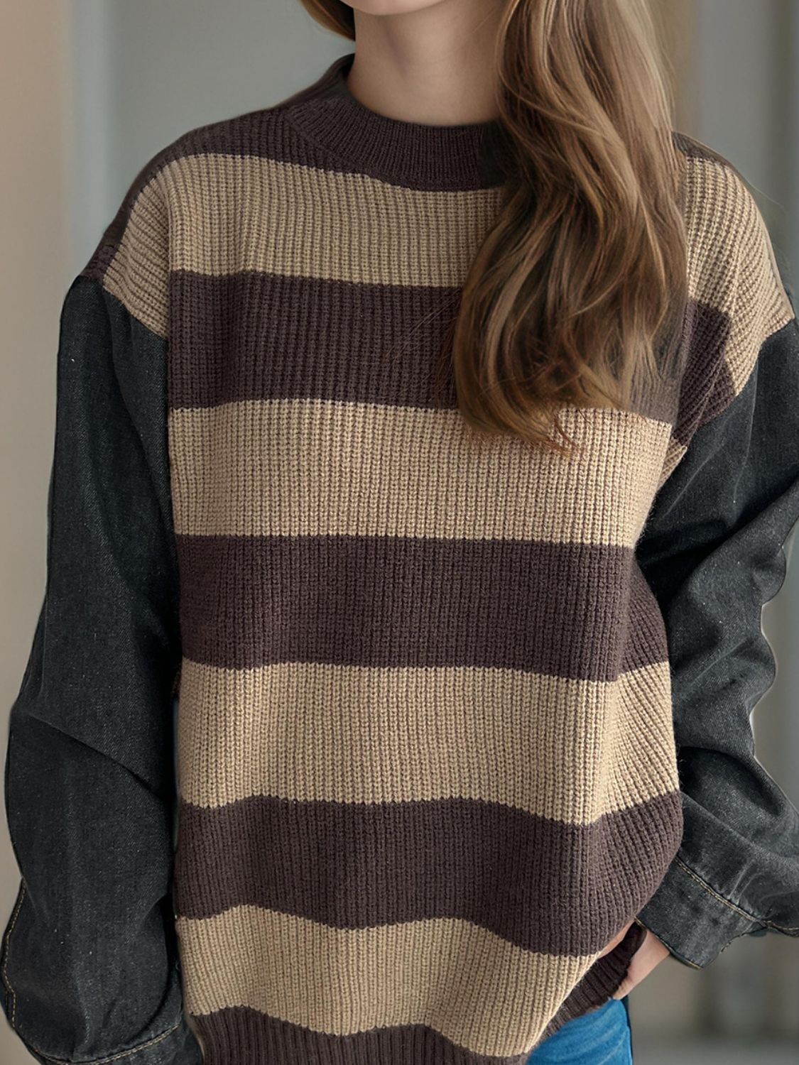 Brown and tan striped knit sweater with dark denim sleeves.