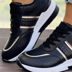 Black lace-up sneakers with metallic accents and a chunky white sole.