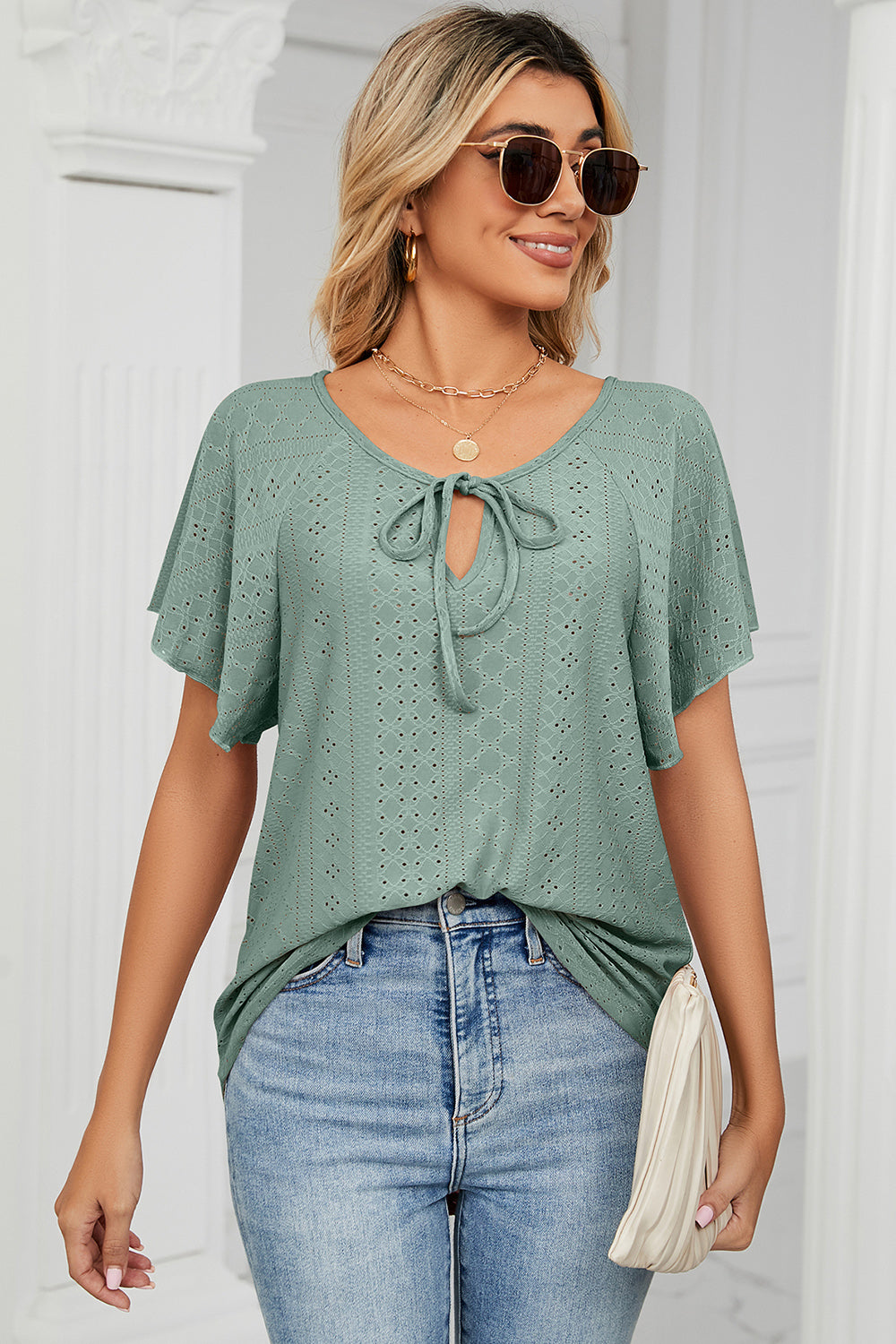 Light green eyelet tie-neck blouse with flutter sleeves and a V-neck.
