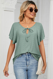 Light green eyelet tie-neck blouse with flutter sleeves and a V-neck.