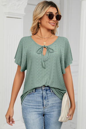Light green eyelet tie-neck blouse with flutter sleeves and a V-neck.