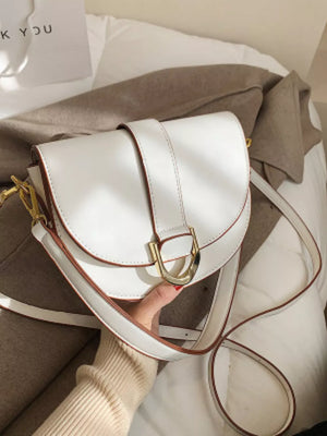 Chic white semi-circular flap crossbody bag with gold buckle detail.