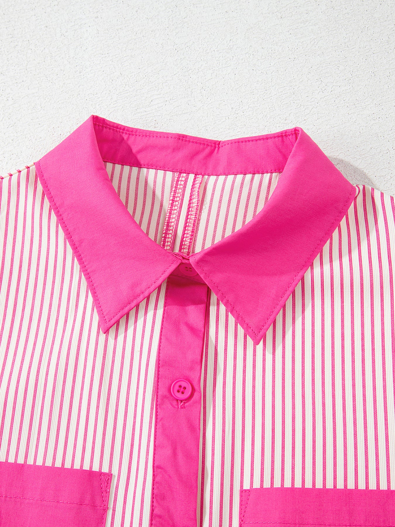 Button-down mini dress with pink and white stripes, pink collar, and button detail.