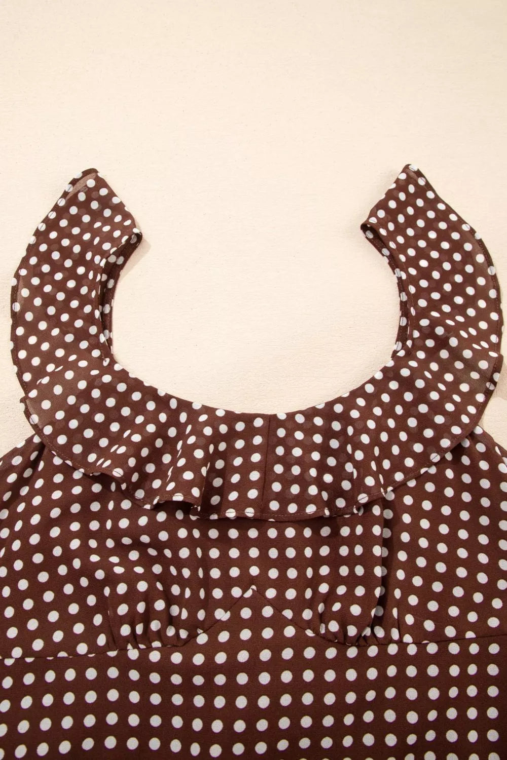 Brown polka dot maxi dress with ruffled neckline and polyester fabric.