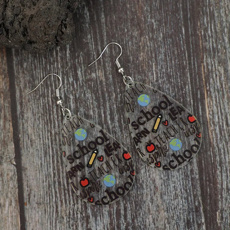 Transparent teardrop earrings with school-themed graphics like apples, pencils, and globes.