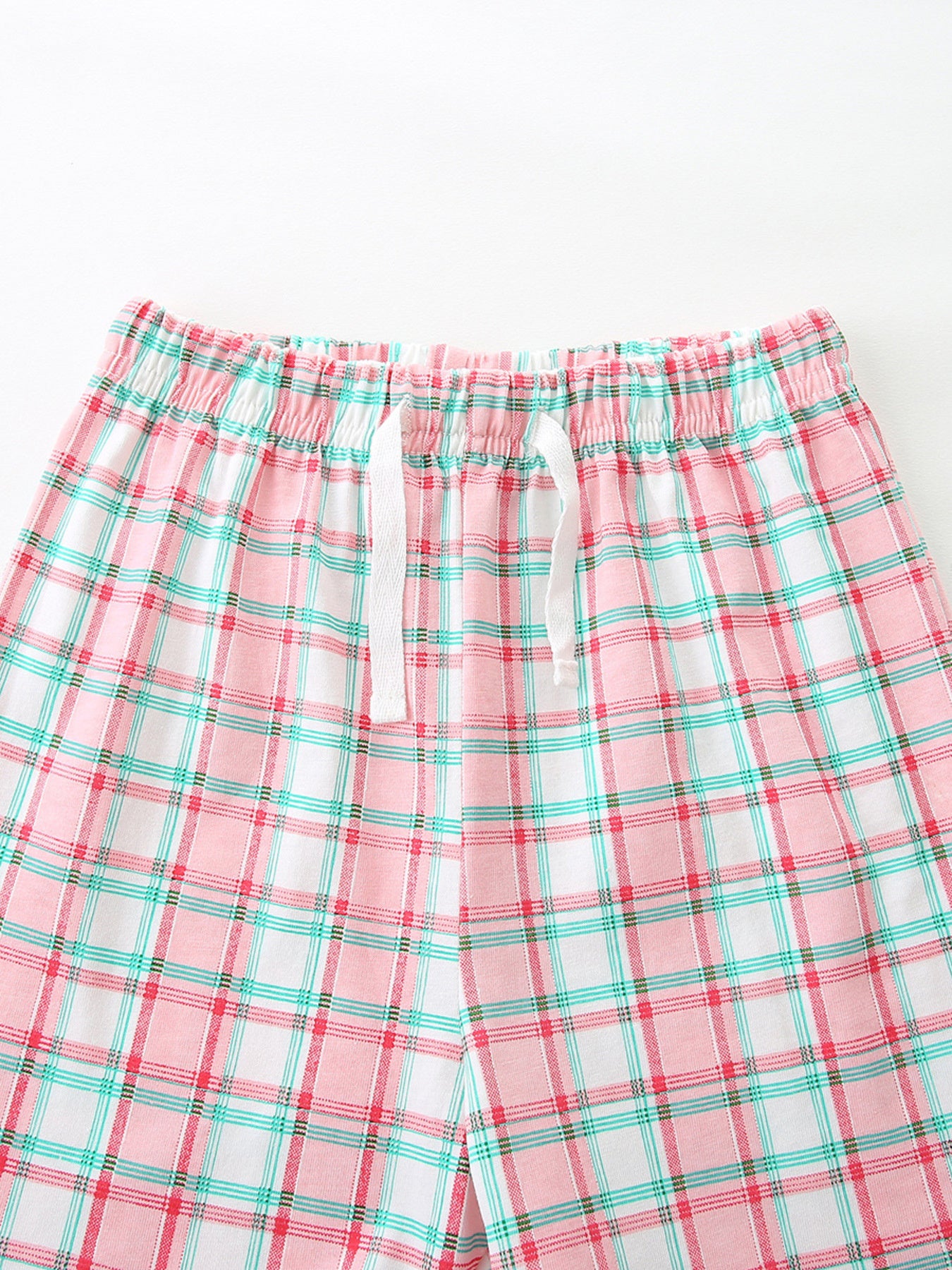 Girls' pink plaid cotton shorts with white drawstring and elastic waistband.