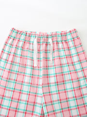 Girls' pink plaid cotton shorts with white drawstring and elastic waistband.