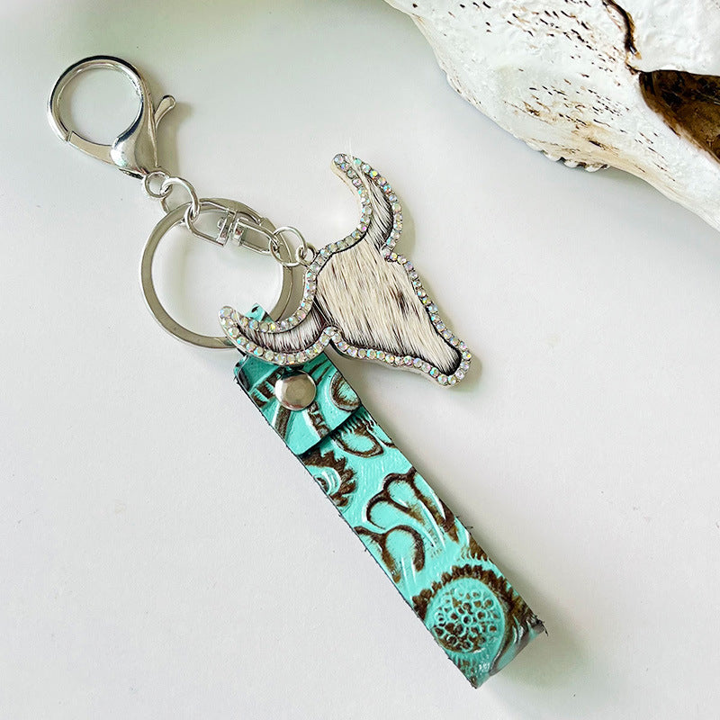 Embossed leather bull keychain with crystal accents and turquoise strap.