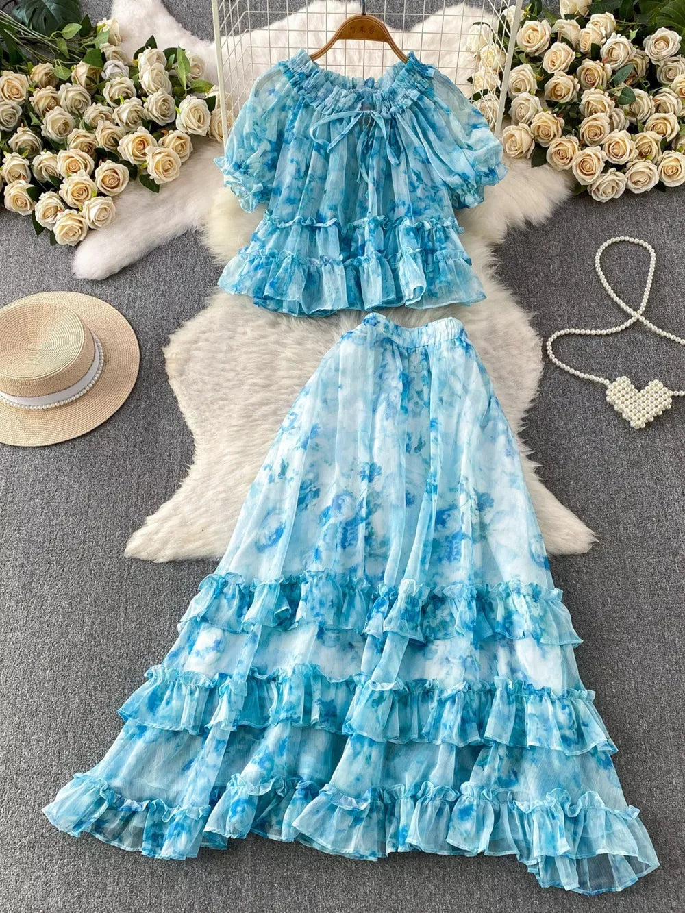 Sky blue floral ruffle set with bow detail, featuring a ruffled neckline and short sleeves.