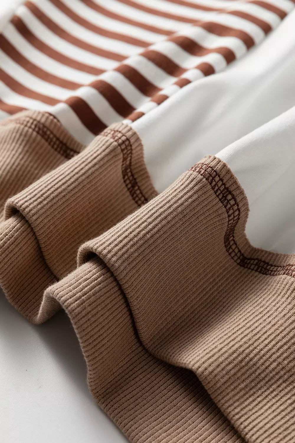 Chic colorblock sweatshirt with brown and white stripes and contrast stitching on ribbed cuffs.