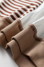 Chic colorblock sweatshirt with brown and white stripes and contrast stitching on ribbed cuffs.