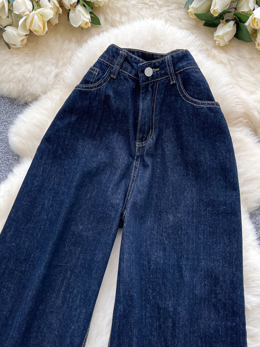 Dark wash maternity jeans with a high rise and wide leg, made of denim.