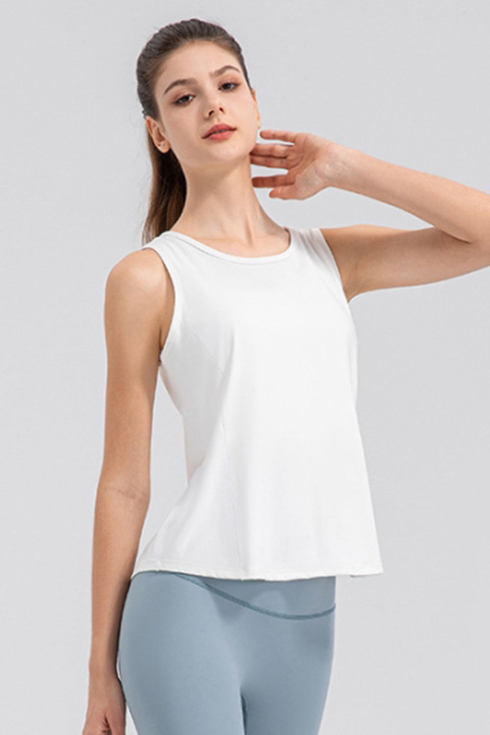 White performance tank top with a curved back panel detail and round neckline.