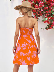 Orange floral smocked bandeau mini dress with A-line skirt.