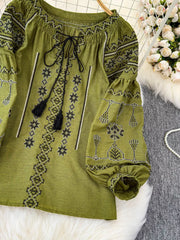 Green embroidered tie neck blouse with tassels and puff sleeves.