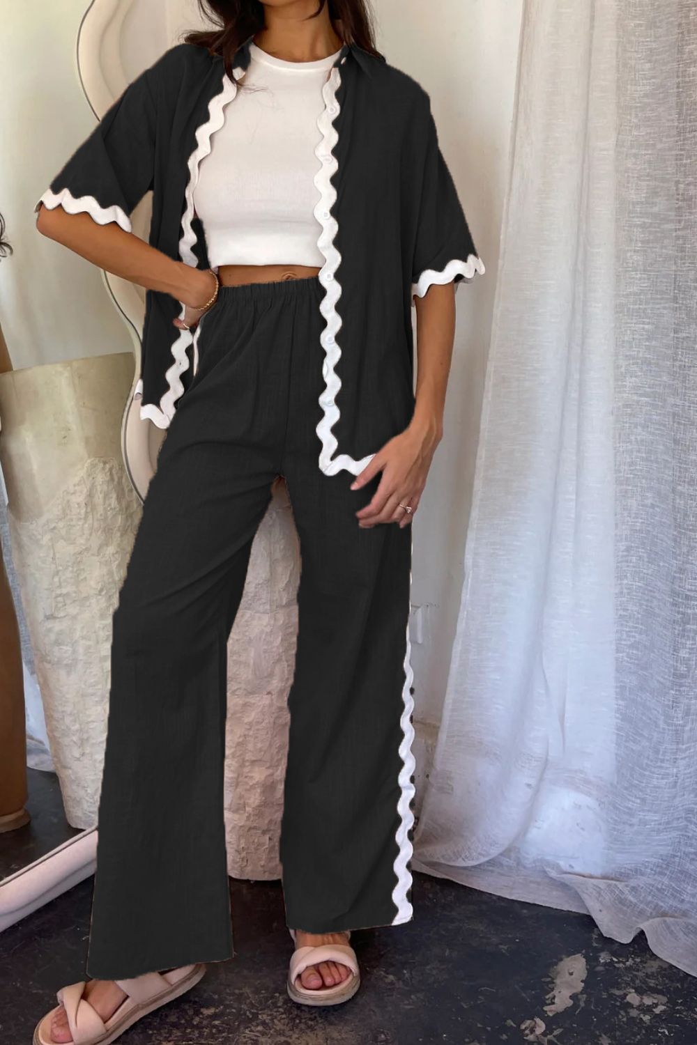 Black loungewear set with white scalloped trim on shirt and pants.