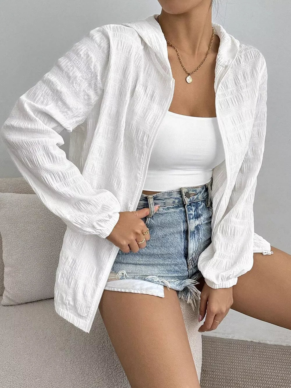 White crinkled lightweight hooded jacket with zip closure and elastic cuffs.