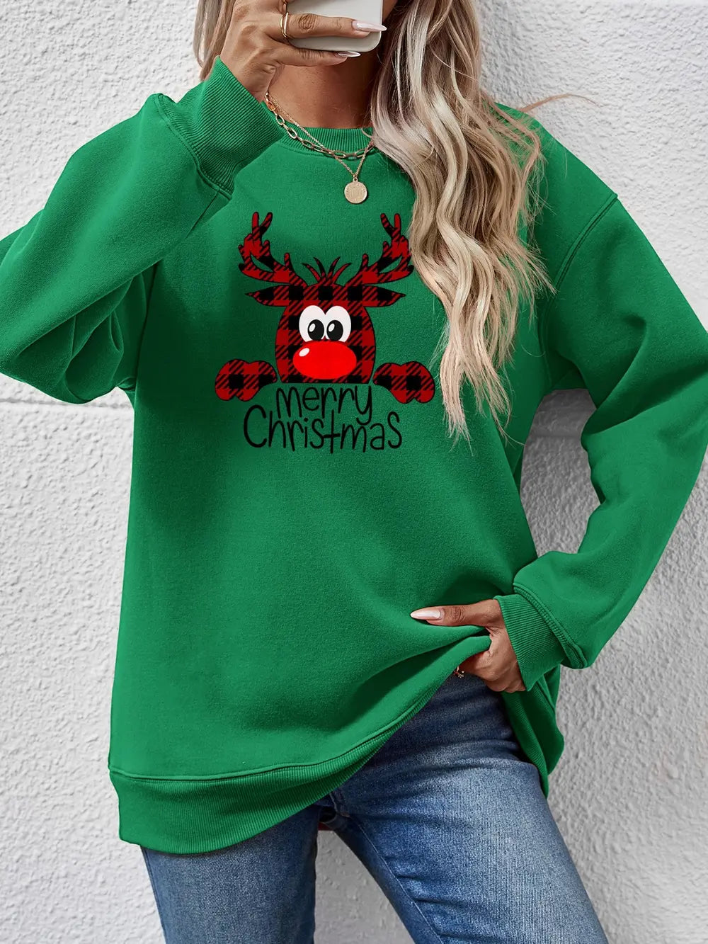 Green crewneck sweatshirt with plaid reindeer and Merry Christmas graphic.