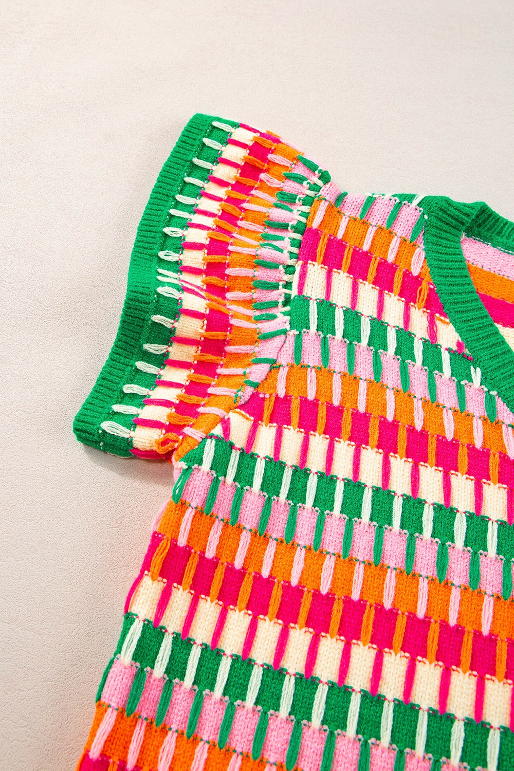 Geometric knit flutter sleeve top in green and orange with a textured pattern and ruffled sleeves.