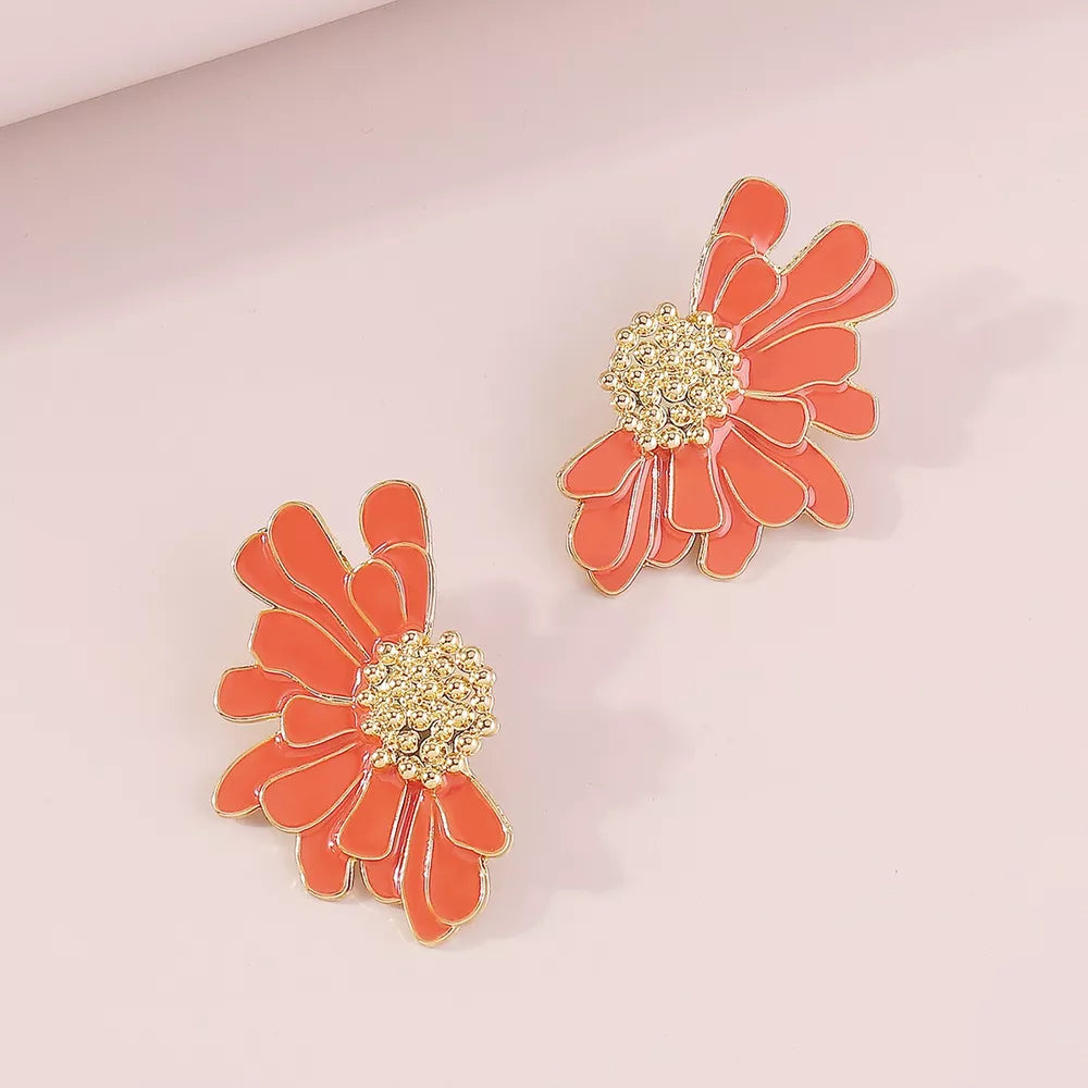 Orange flower stud earrings with gold textured center and gold trim.