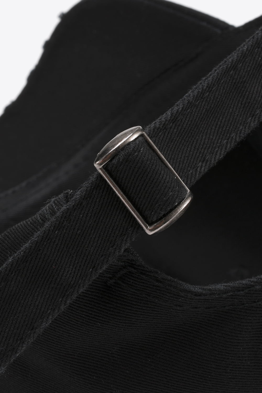 Black baseball cap with adjustable strap and metal buckle detail