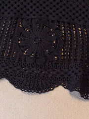 Black crochet tank top with floral overlay detail and scalloped hem.