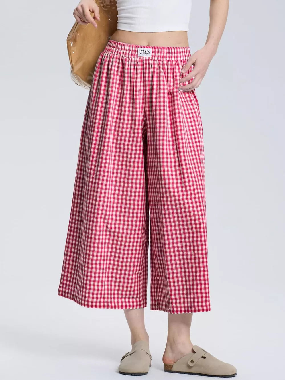 Gingham check wide-leg maternity pants in rose red with an elastic waistband.