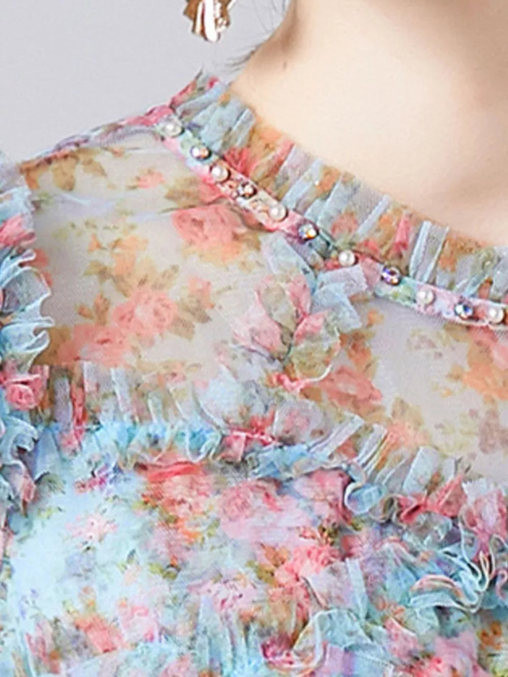 Sheer floral dress with ruffled neckline and pearl and crystal embellishments.