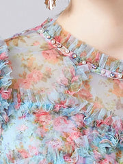 Sheer floral dress with ruffled neckline and pearl and crystal embellishments.