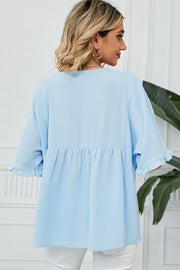 Light blue blouse with gathered yoke, flutter sleeves, and ruffled cuffs.