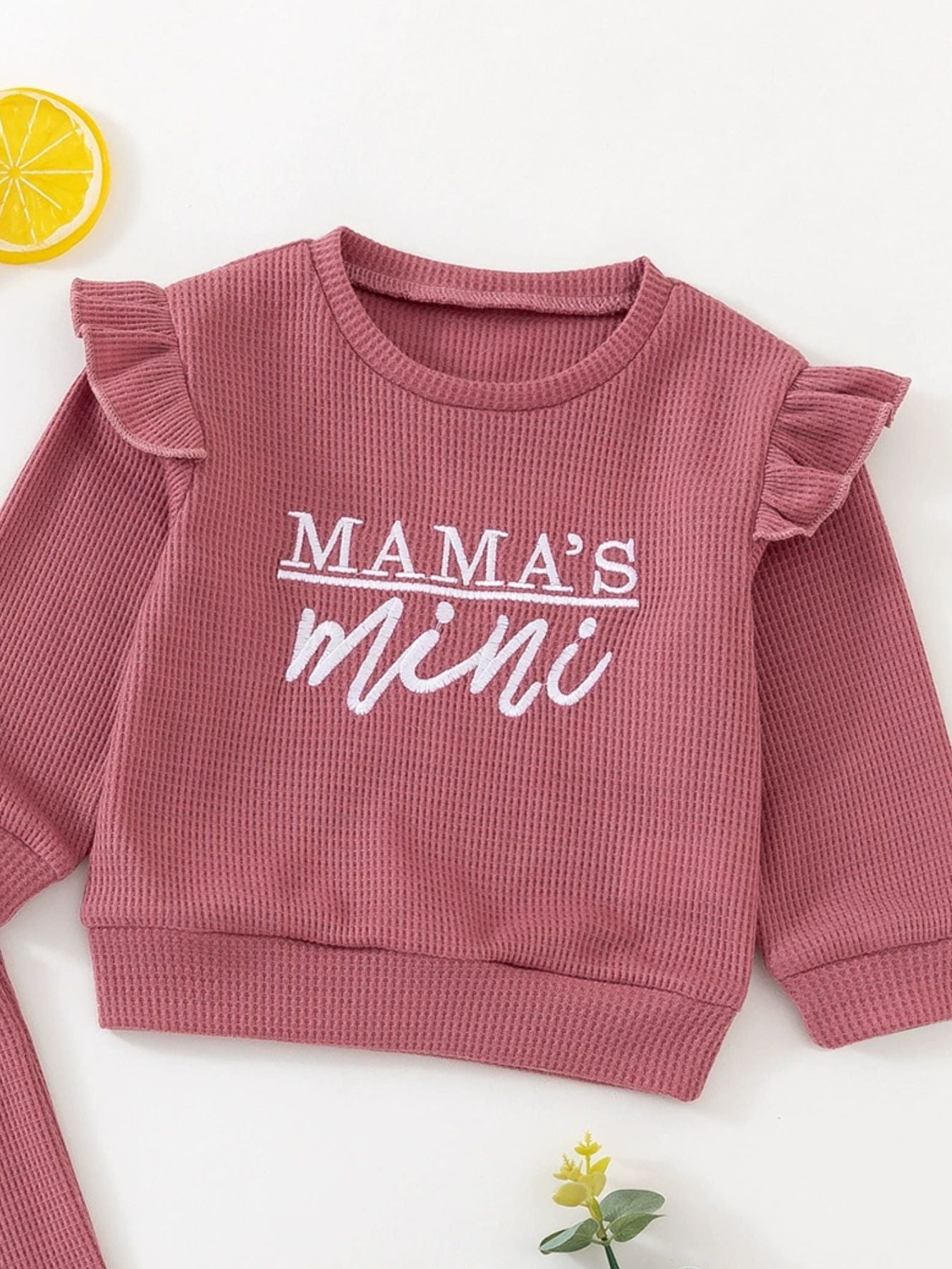 Dusty rose waffle knit toddler top with ruffled sleeves and "Mama's mini" graphic.