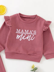 Dusty rose waffle knit toddler top with ruffled sleeves and "Mama's mini" graphic.
