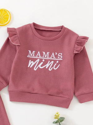 Dusty rose waffle knit toddler top with ruffled sleeves and "Mama's mini" graphic.
