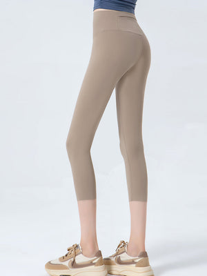 Beige sculpted crop leggings with a high waistband and subtle mesh detail at the hem.