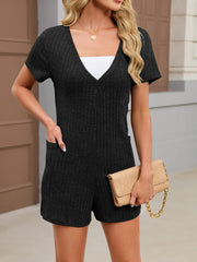 Black textured V-neck knit romper with short sleeves and pockets.