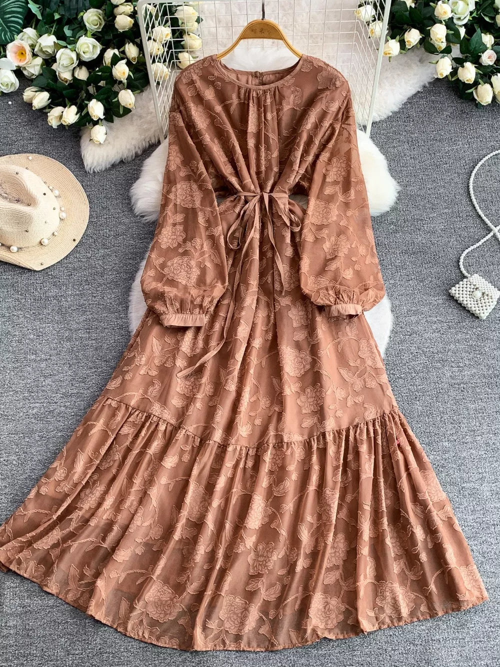 Embroidered tie-waist dress in rust with long sleeves and tiered skirt.