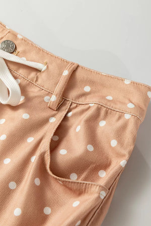 Polka dot maternity trousers in peach with white dots, drawstring waist, and wide leg cut.