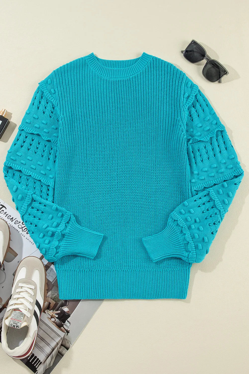 Turquoise knit sweater with textured cutout sleeves and crew neck.