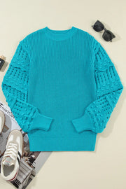 Turquoise knit sweater with textured cutout sleeves and crew neck.