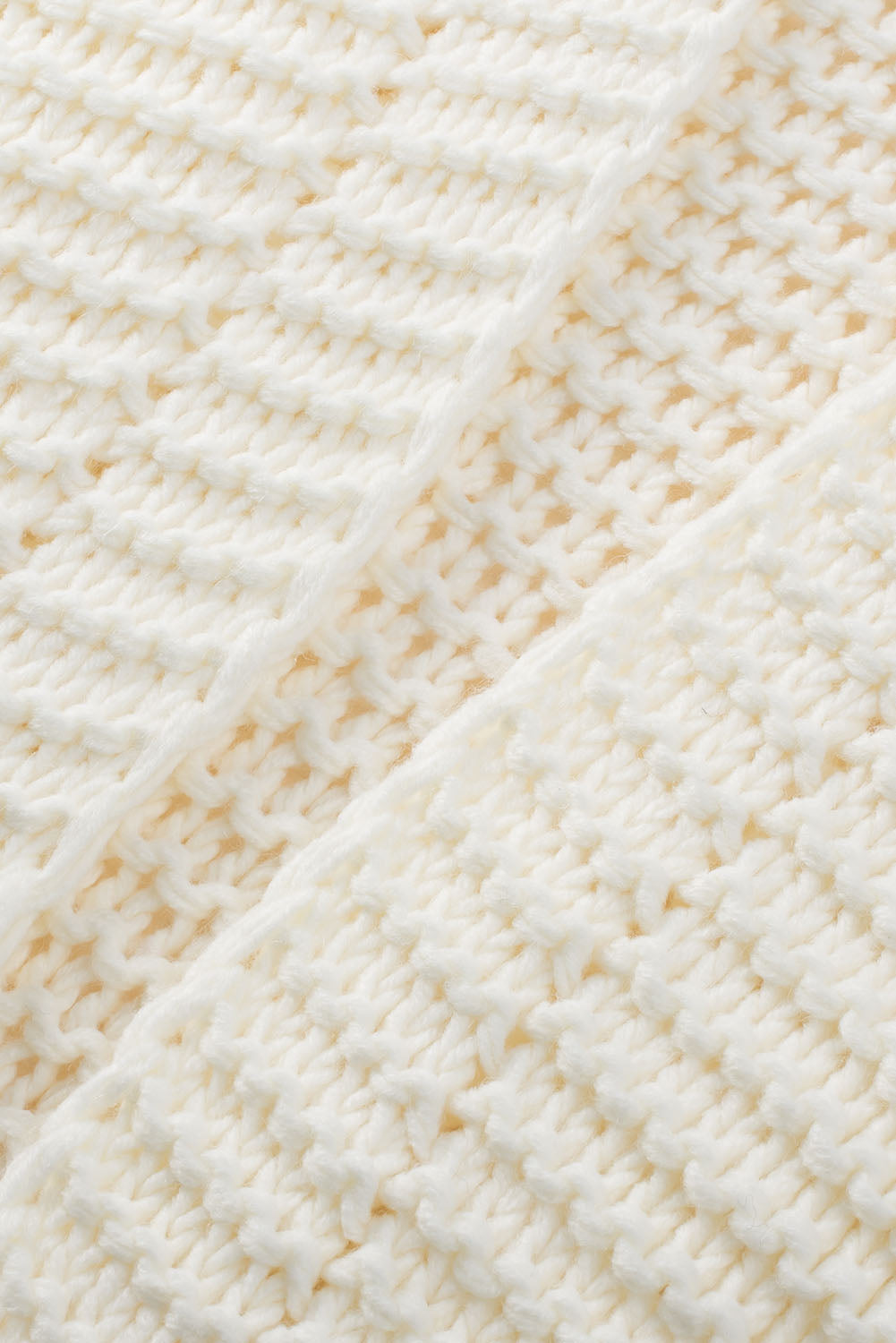 Textured knit cocoon cardigan in cream acrylic with a waffle knit pattern.