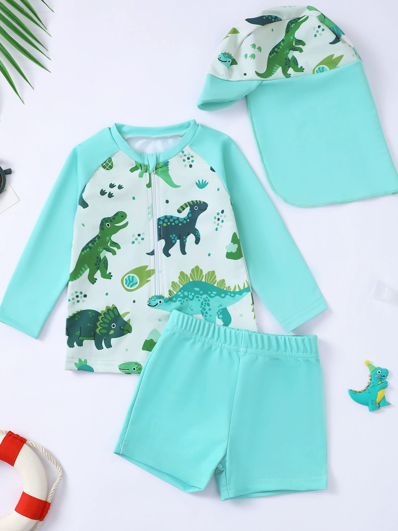Children's turquoise dinosaur print swimwear set with long sleeves and shorts.