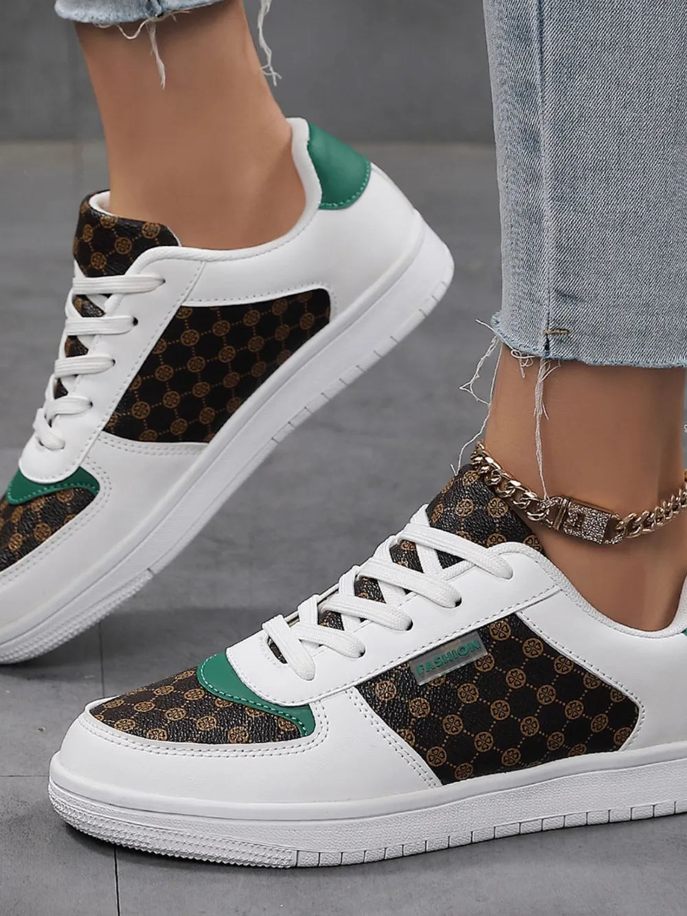 Patterned panel court sneakers in white with brown monogram canvas and green accents.