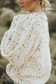 Cream speckled puff sleeve knit sweater with textured sleeves.