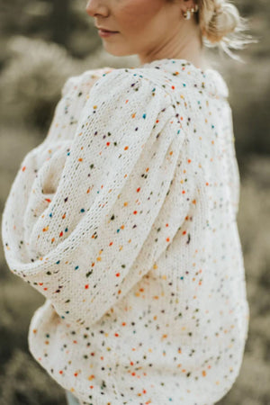 Cream speckled puff sleeve knit sweater with textured sleeves.