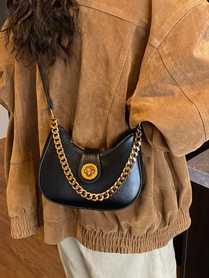 Black crescent mini shoulder bag with gold chain accent and clasp closure.