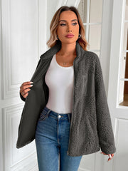 Dark gray teddy fleece jacket with patch pocket detail and zip front, worn open over a white tank top.