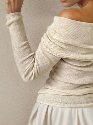 Ivory knit sweater with off-the-shoulder neckline and ruched detail.